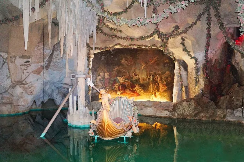 A gilded swan boat on the still green water of the underground lake in the Venus Grotto